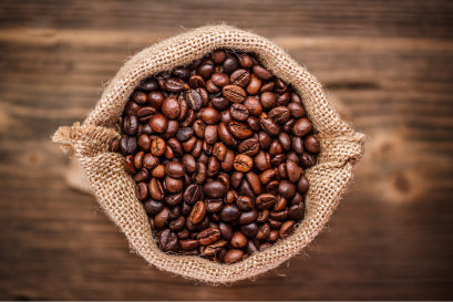 Bag of roasted organic coffee beans in a burlap sack, highlighting natural energy and focus benefits. A foundational ingredient in JostArriba mushroom coffee, blended with adaptogens and nootropics for brain health and mood support.