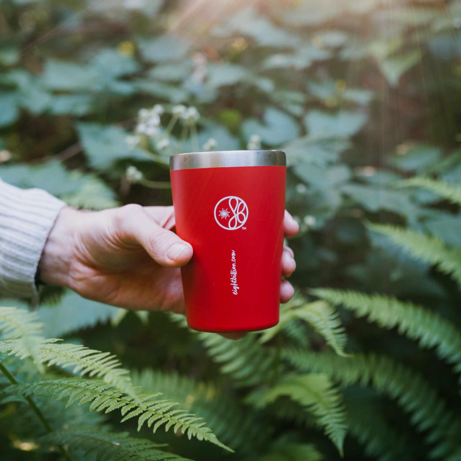 Hand holding a reusable Eight Billion red travel mug in nature.
Eco-friendly insulated tumbler designed for JostArriba mushroom coffee, supporting sustainability and reducing single-use waste