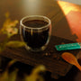 Glass cup of JostArriba adaptogenic coffee on a wooden board beside coffee beans, spoon, and sachet. Functional mushroom drink by Eight Billion made with lion’s mane, reishi, and ashwagandha for focus, mood, and energy. Warm, minimalist wellness vibe.